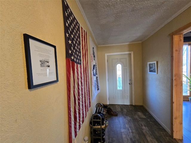 entryway with a textured ceiling, dark wood-type flooring, and ornamental molding