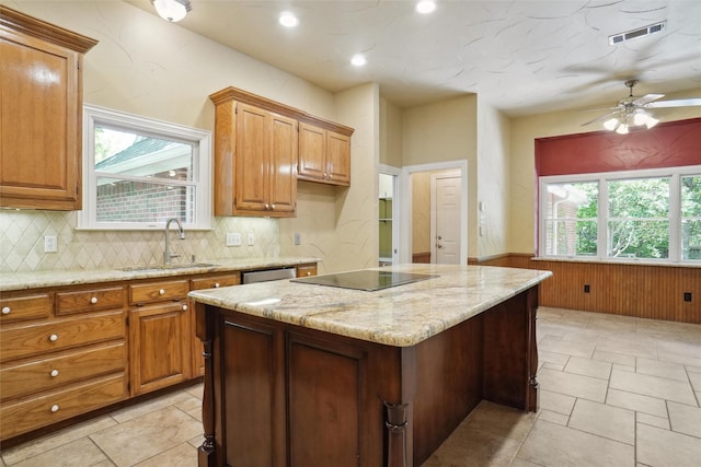 kitchen with a wealth of natural light, sink, a center island, stainless steel dishwasher, and black electric stovetop