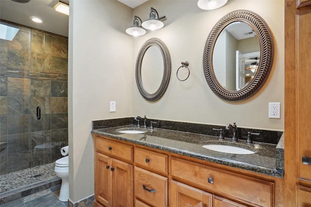 bathroom featuring a shower with door, vanity, tile patterned floors, and toilet