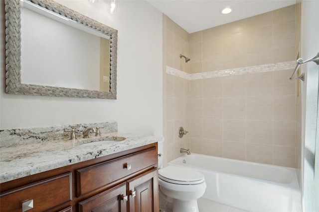 full bathroom featuring tile patterned flooring, tiled shower / bath, vanity, and toilet