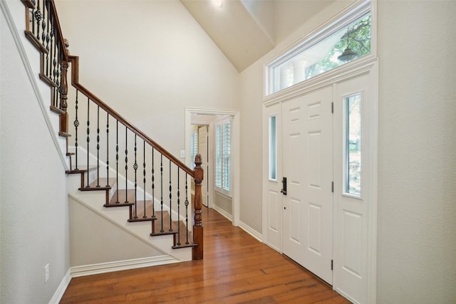 entrance foyer featuring a towering ceiling and hardwood / wood-style floors