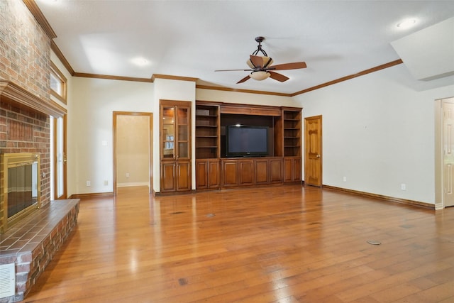 unfurnished living room with ceiling fan, ornamental molding, a fireplace, and light wood-type flooring