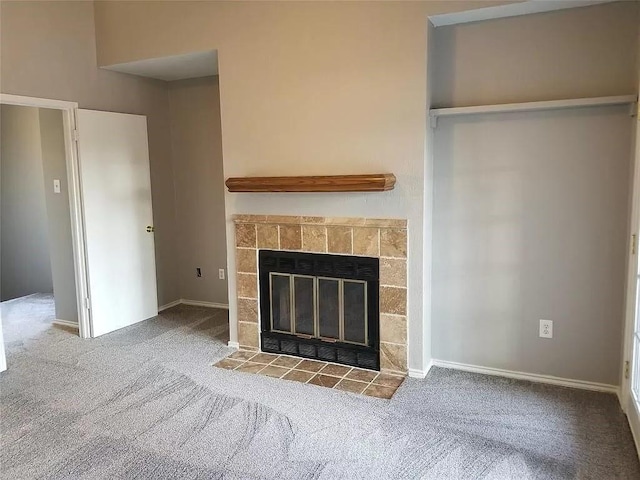 unfurnished living room with light colored carpet and a tiled fireplace