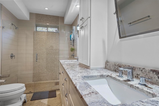 bathroom featuring tile patterned floors, toilet, vanity, and a shower with shower door