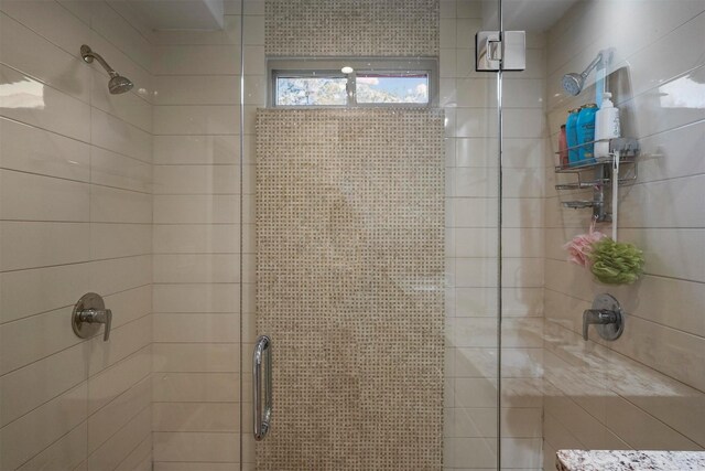 bathroom with a shower with door