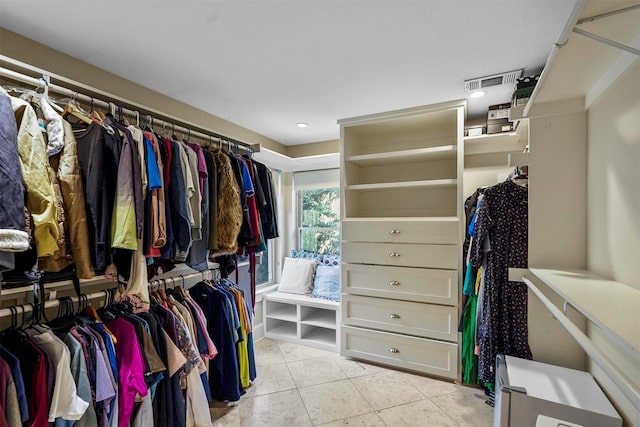 walk in closet with light tile patterned floors