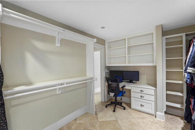 office space featuring built in desk and light tile patterned floors