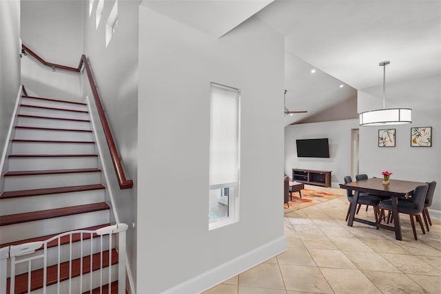 staircase with tile patterned floors and vaulted ceiling