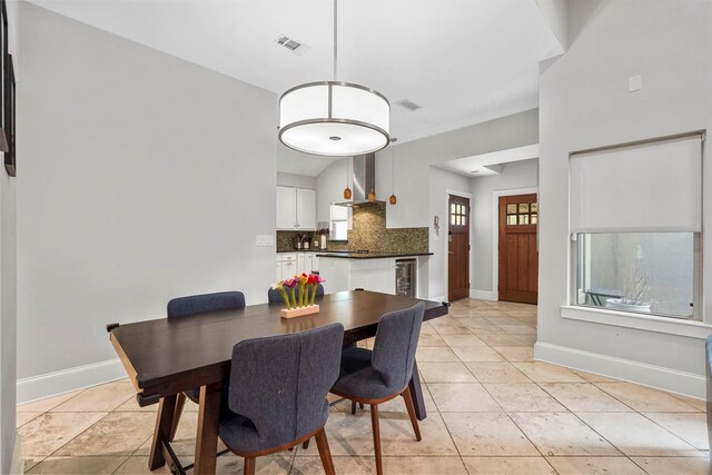 dining room featuring vaulted ceiling, wine cooler, and light tile patterned floors