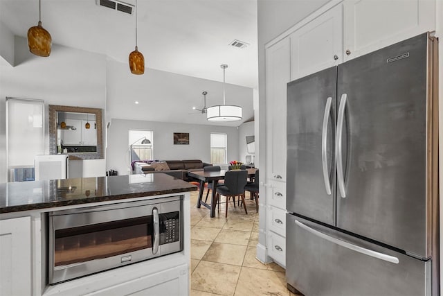 kitchen featuring dark stone countertops, appliances with stainless steel finishes, ceiling fan, white cabinetry, and decorative light fixtures