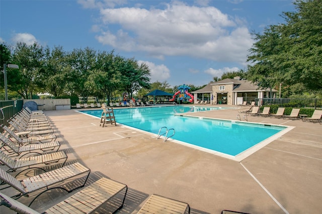 view of swimming pool featuring a playground and a patio area