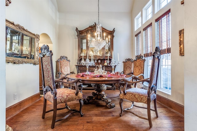 dining room with a healthy amount of sunlight, an inviting chandelier, and dark hardwood / wood-style floors