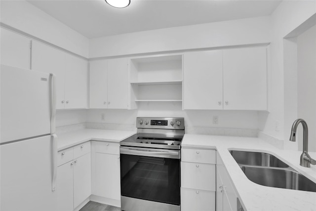 kitchen with sink, electric stove, white fridge, and white cabinetry