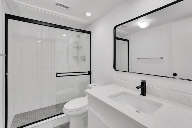 bathroom with a shower with door, vanity, and toilet