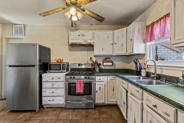 kitchen featuring sink, dark tile patterned floors, ceiling fan, and appliances with stainless steel finishes