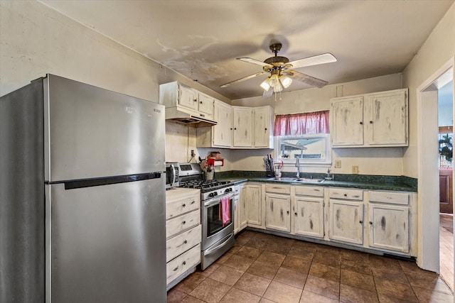 kitchen featuring sink, stainless steel appliances, ceiling fan, and dark tile patterned flooring