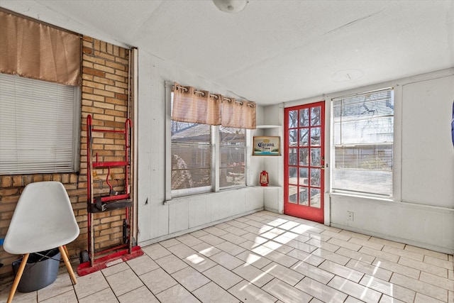 interior space featuring brick wall and vaulted ceiling