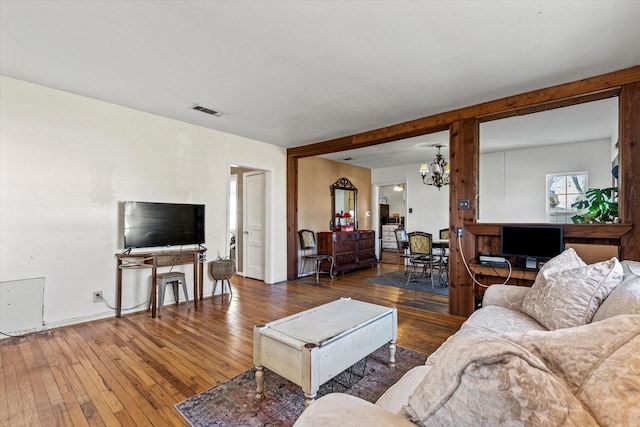 living room featuring wood-type flooring and a notable chandelier