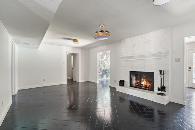 living room with a brick fireplace and dark parquet floors