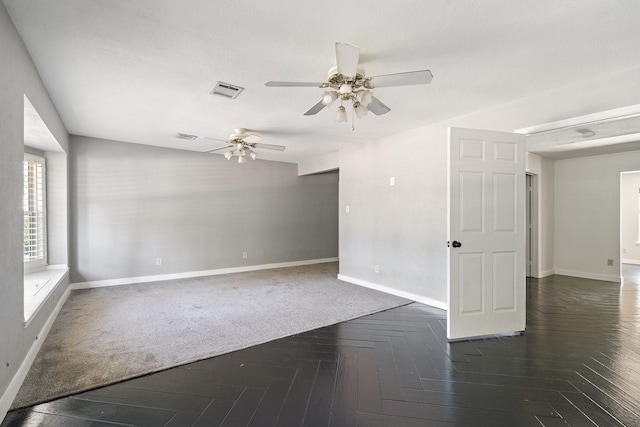 empty room with ceiling fan and dark parquet floors