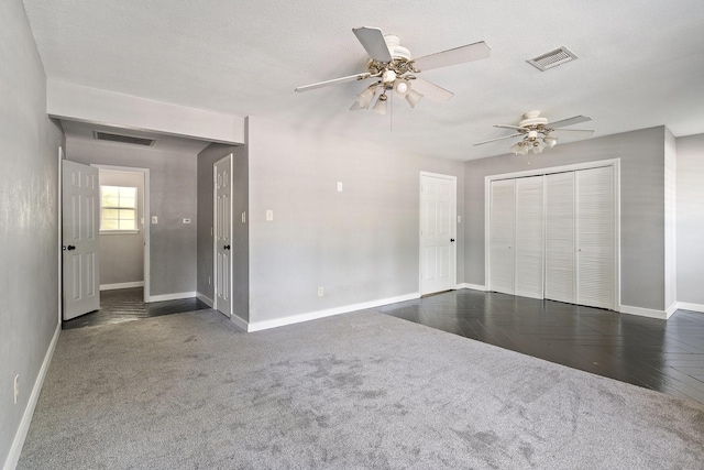 interior space featuring ceiling fan and dark carpet