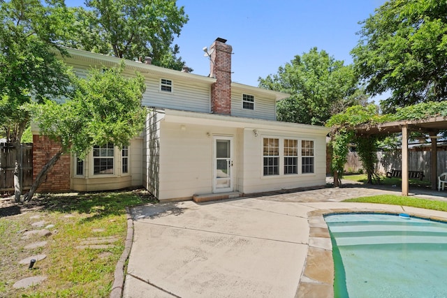 back of house with a fenced in pool and a patio area