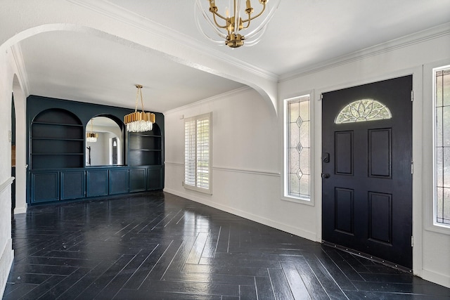 foyer featuring ornamental molding, dark parquet floors, and a chandelier