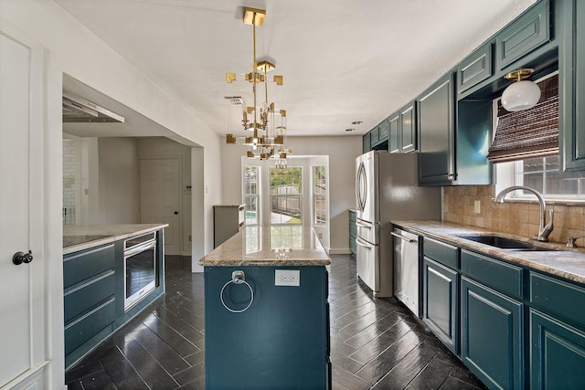 kitchen featuring sink, decorative backsplash, hanging light fixtures, a kitchen island, and appliances with stainless steel finishes