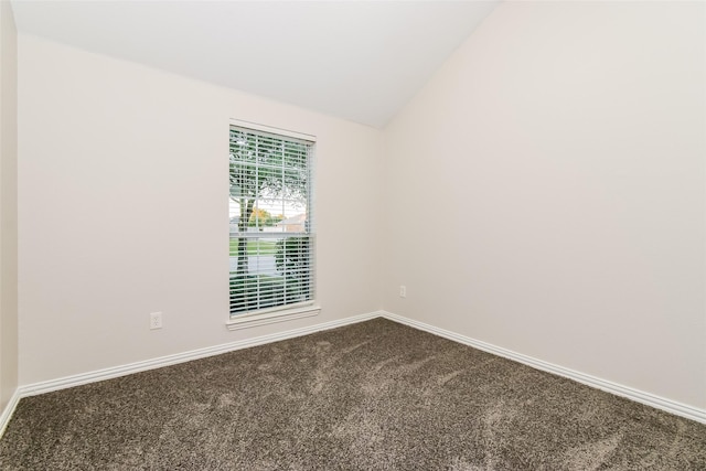 carpeted spare room with vaulted ceiling