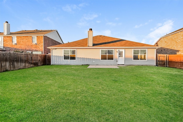 rear view of property featuring a yard and a patio area