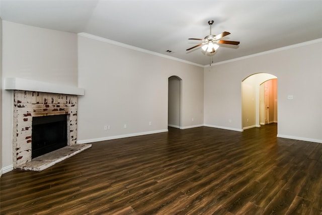 unfurnished living room featuring a fireplace, ceiling fan, crown molding, and dark wood-type flooring