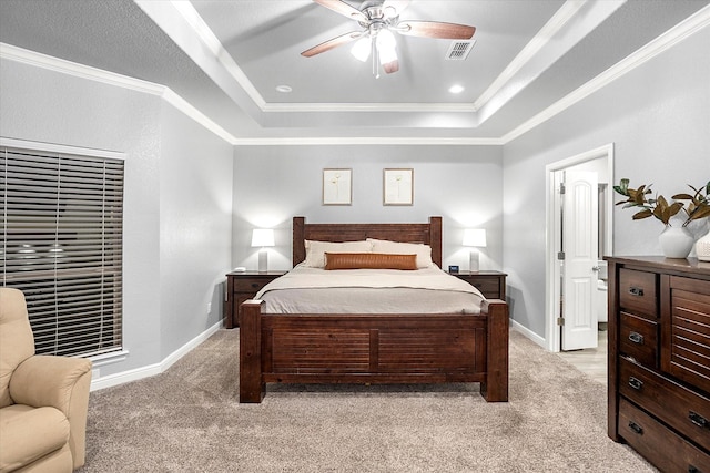 bedroom with ceiling fan, a tray ceiling, crown molding, and light colored carpet