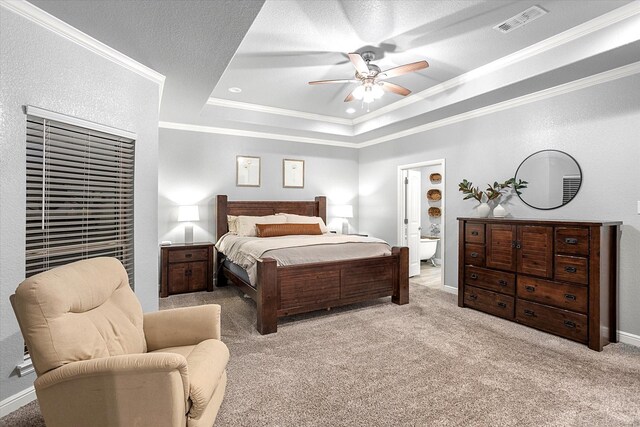 carpeted bedroom with ceiling fan, connected bathroom, and a tray ceiling