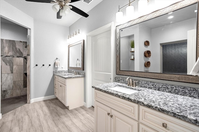 bathroom with ceiling fan, tiled shower, hardwood / wood-style floors, and vanity