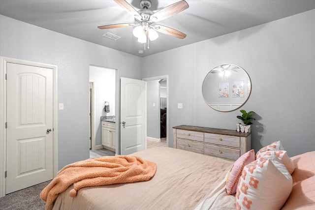 bedroom featuring ensuite bathroom, ceiling fan, and light colored carpet