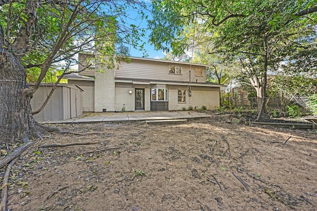 back of property with a patio and a shed