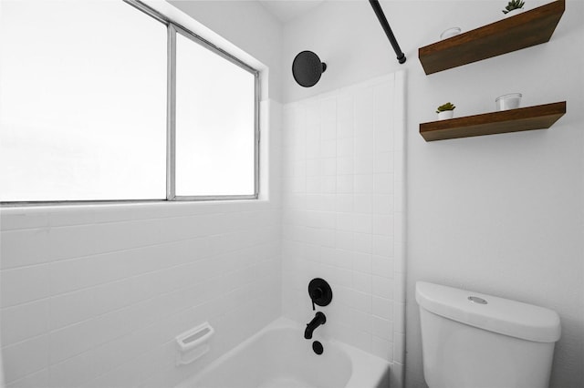 bathroom with toilet and tiled shower / bath