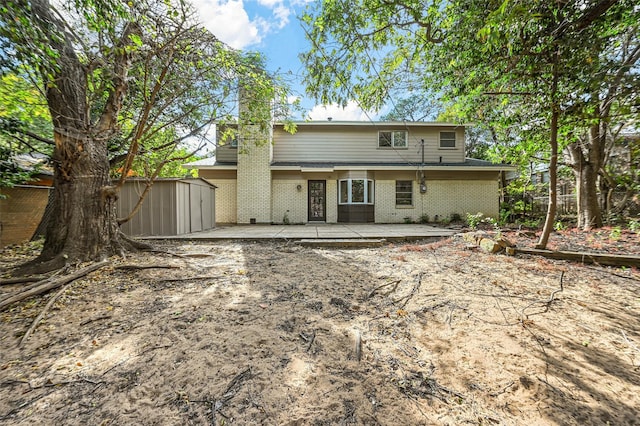 back of house featuring a patio area and a storage shed