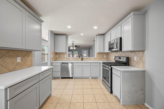 kitchen featuring stainless steel appliances, ceiling fan, light tile patterned floors, and sink