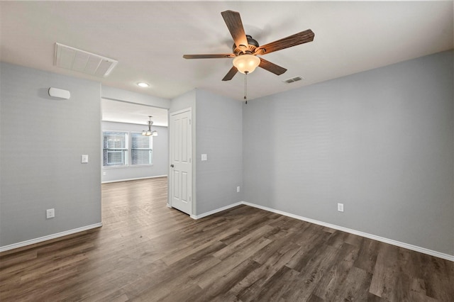 empty room featuring dark hardwood / wood-style floors and ceiling fan with notable chandelier