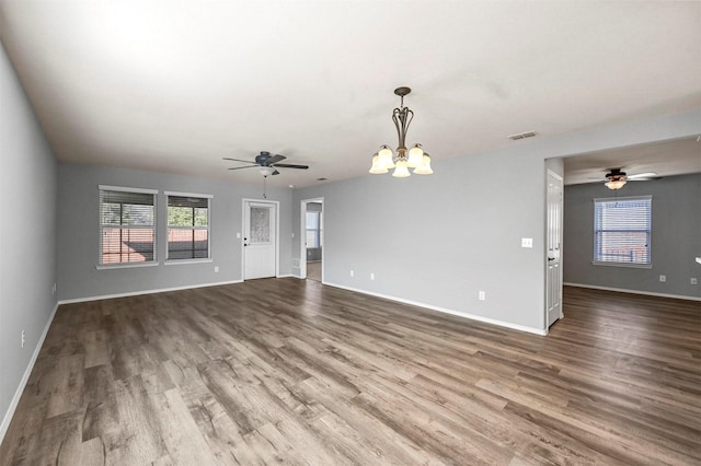 unfurnished living room with wood-type flooring and an inviting chandelier