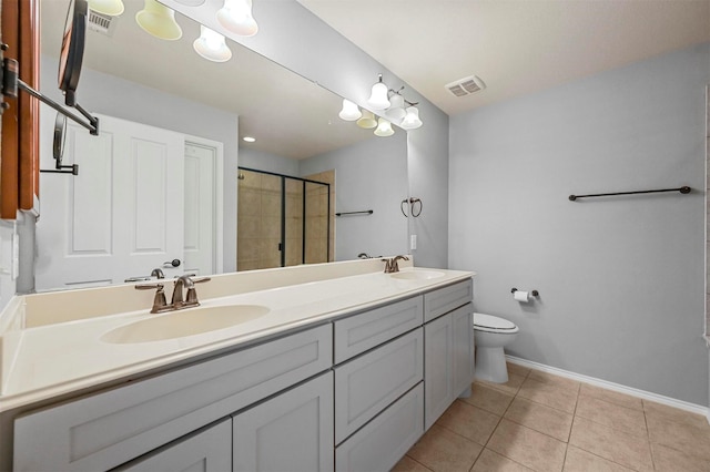 bathroom with vanity, tile patterned flooring, a shower with shower door, and toilet