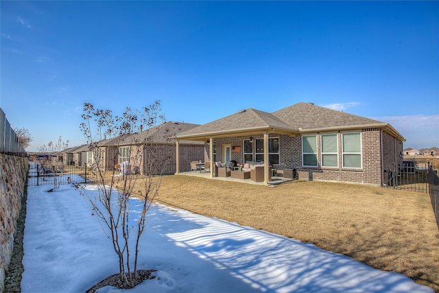 rear view of property featuring outdoor lounge area, a patio, a fenced backyard, and brick siding