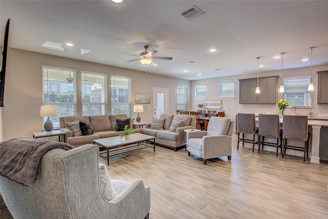 living room with ceiling fan and light hardwood / wood-style floors