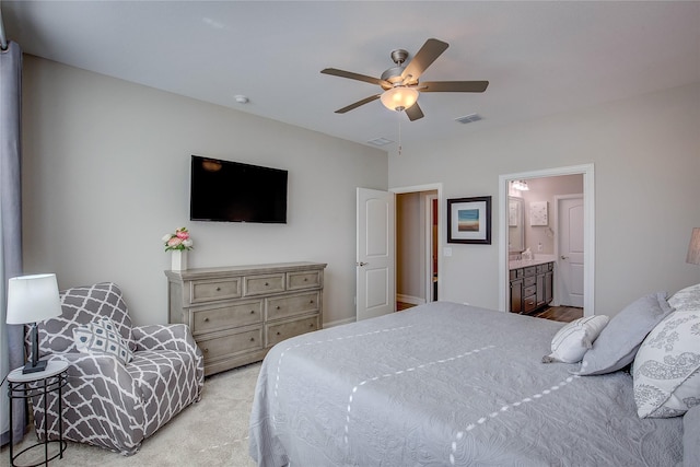 bedroom featuring light carpet, ceiling fan, and ensuite bathroom