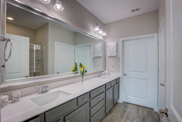 bathroom featuring a shower with shower door, vanity, and hardwood / wood-style flooring