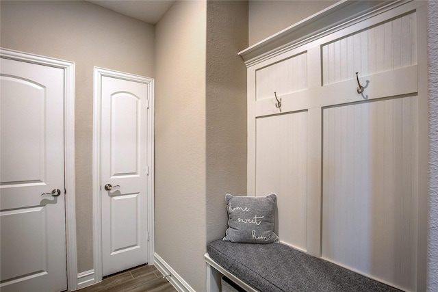 mudroom featuring dark wood-type flooring and baseboards