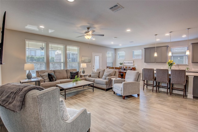 living area with visible vents, ceiling fan, light wood finished floors, and recessed lighting