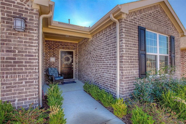 doorway to property featuring brick siding