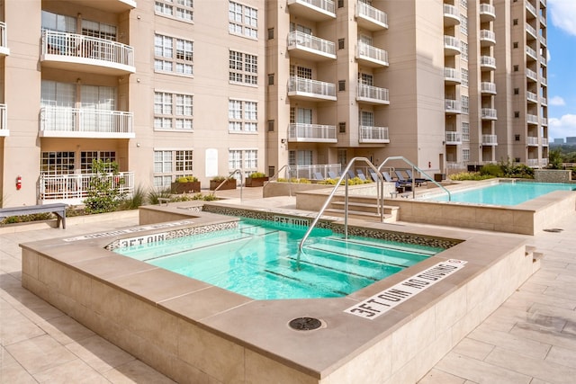 view of pool with a hot tub